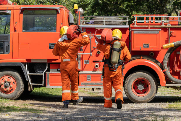 istock Firefighters wearing helmets with fire safety equipment Use Twirl aerosol fire extinguishers to fight oil flames.Preventing fire accidents is an industrial safety concept. 1582668247
