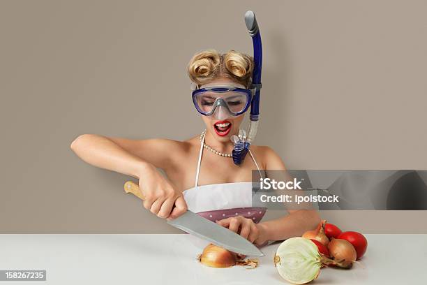 Young Woman Chopping Onions While Wearing A Diving Mask Stock Photo - Download Image Now