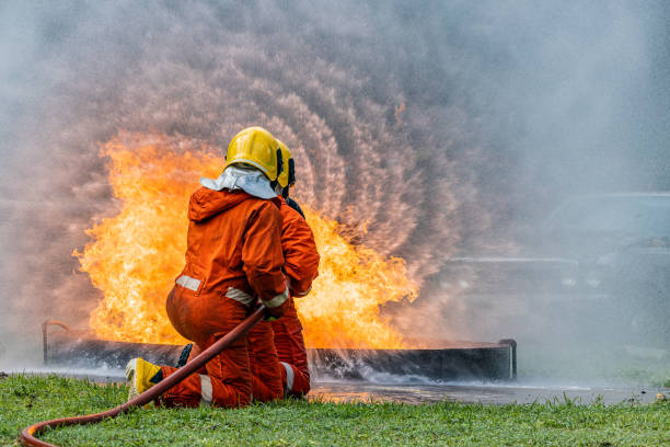 istock Firefighters wearing helmets with fire safety equipment Use Twirl aerosol fire extinguishers to fight oil flames.Preventing fire accidents is an industrial safety concept. 1582672672