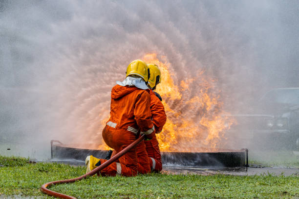 istock Firefighters wearing helmets with fire safety equipment Use Twirl aerosol fire extinguishers to fight oil flames.Preventing fire accidents is an industrial safety concept. 1582673222