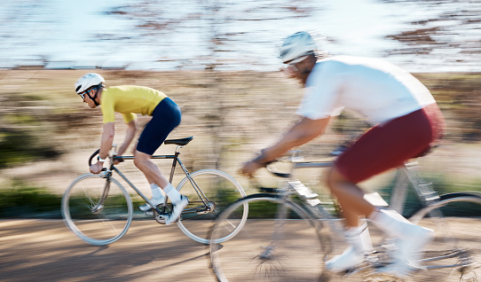 Race, cycling and fast with men in park for training, motion blur and cardio workout. Marathon, sports and workout cyclists riding on bike in outdoor for speed, challenge and fitness for competition