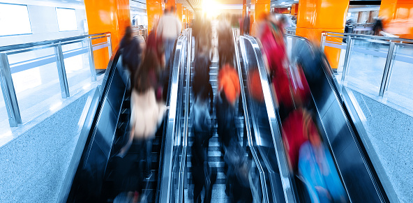 Top view of passengers moving at escalator in the subway station