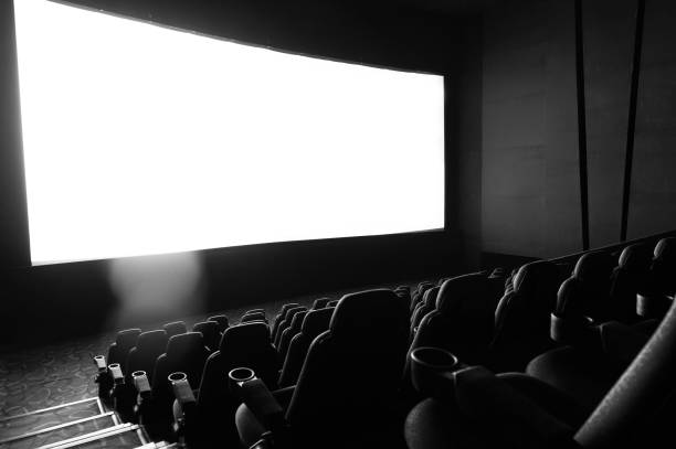 istock Dark movie theatre interior with screen and chairs 1582695413