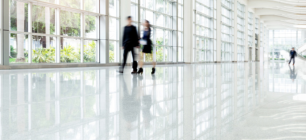 Group of business people walking in glass building