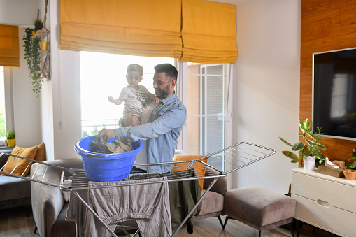 Caring Father Showing Toddler The Basics Of House Laundry Chores