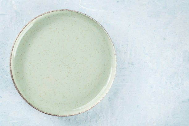 An empty green plate, overhead flat lay shot on a slate background