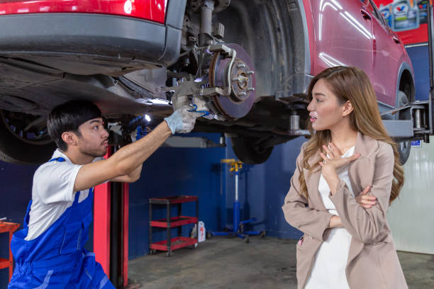istock A car mechanic is checking items that need replacement parts for a customer who repairs a car at a garage. 1582732974