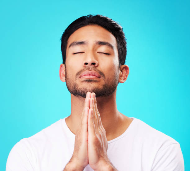 prier, homme et mains en méditation ou adorer dieu pour la foi ou la croyance en la spiritualité, la pleine conscience et la paix en studio. chrétien, prière et personne avec religion et zen sur fond bleu - praying saying grace serene people guidance photos et images de collection