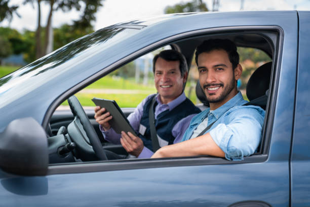 istock Happy man with his driving instructor smiling in the car 1582801838