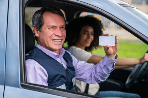 istock Happy driving instructor holding a diver's license 1582801844