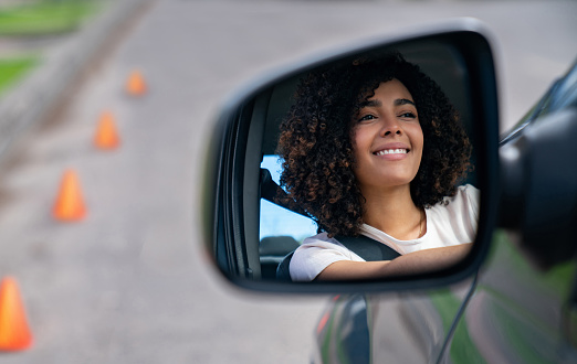 Happy African American woman looking confident on her driving test - learning to drive concepts
