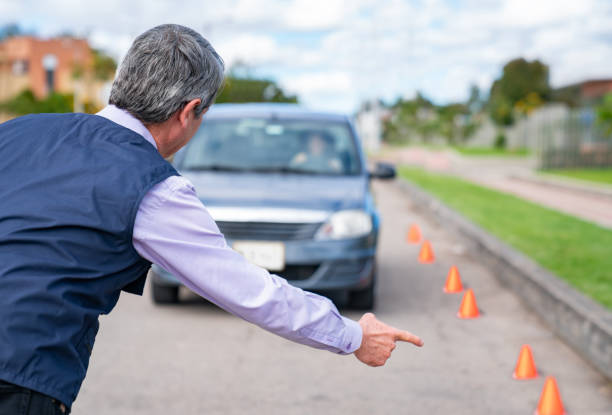 Driving instructor giving instructions to a woman taking driving lessons