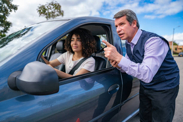istock Driving instructor giving instructions to a woman taking driving lessons 1582801856