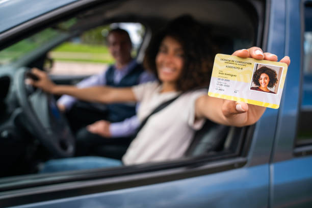 istock Woman passing her driving test and getting her driver's license 1582801864