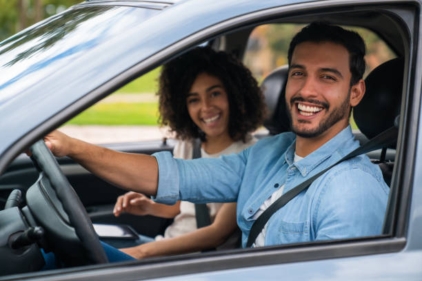 istock Happy couple going on a road trip and driving a car 1582802386