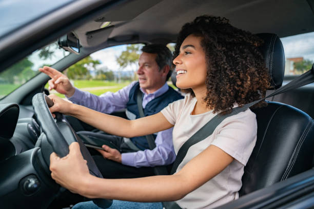 fahrlehrer bringt frau das fahren bei - id card identity showing women stock-fotos und bilder