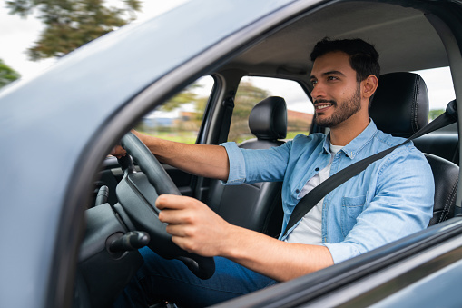 Rear view of man driving car on the highway - Transportation lifestyle concept