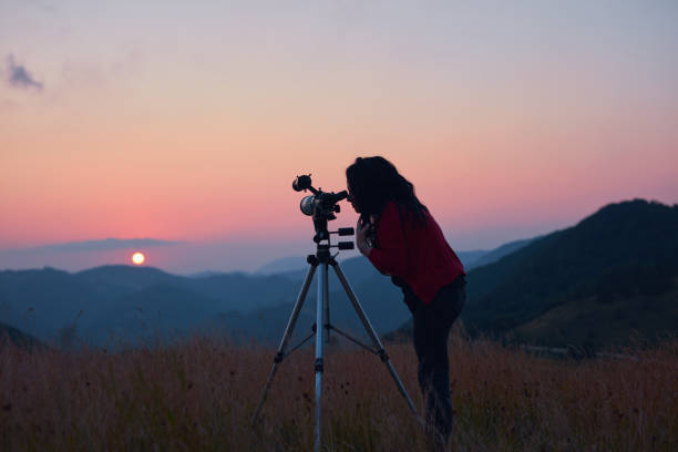 istock Female astronomer looking at the sun with a telescope. 1582810429