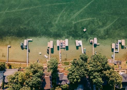 An aerial view of boats moored in a tranquil harbor by a beachfront