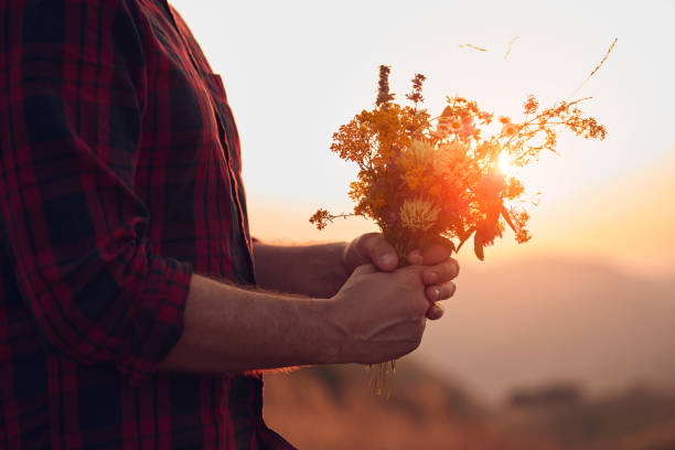 istock Man holding field flowers in nature. 1582814332