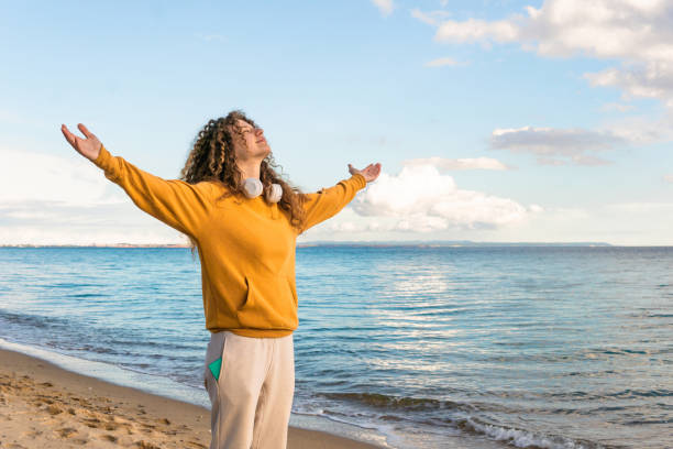 istock A woman enjoys with open arms on the beach 1582828479