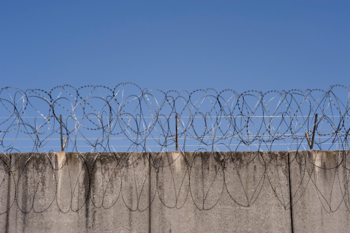 Prison wall with barbed wire in Frankfurt, Germany.