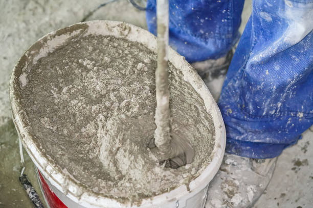 istock Mortar cement paste, mostly dry, mixed in bucket at house construction site, closeup detail from above 1582838268