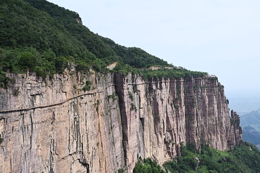 Hui county, Xinxiang City, Henan Province,\nSouth Taihang Huilong Tianjie Mountain, national AAAA tourist scenic spot, 1763 meters above sea level.\nHere, the mountains, cliffs, vegetation covered, the scenery is magnificent.\nOn the mountainside, stone paths have been built along the cliff face for walking sightseeing.