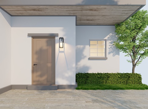 The entrance to the new house with a large wooden door with wall lights and small windows. In the evening, saw the shadow of a big tree across the stone floor and walls of the house.3d rendering