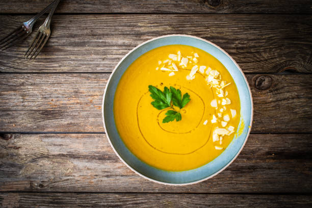 istock Cream carrot soup with almonds on wooden table 1582885759
