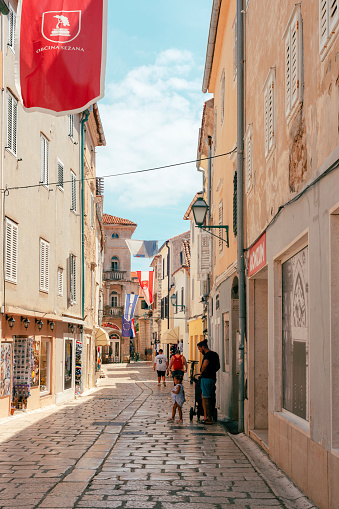 Rab Croatia - 4 July 2023: Main street of old town Rab with walking people.
