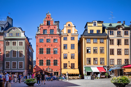 Clear blue dusk skies above the colourful townhouses and quaint restaurants of historic Stortorget, Great Square, the iconic landmark plaza on Gamla Stan in the heart of Stockholm, Sweden's vibrant capital city.