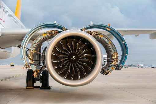 Jet engine. A modern, new generation, jet-powered passenger aircraft is waiting at the airport. Aircraft parked with open hatches for jet engine maintenance.