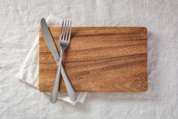istock Wood plate with fork and knife on linen tablecloth 1582903483