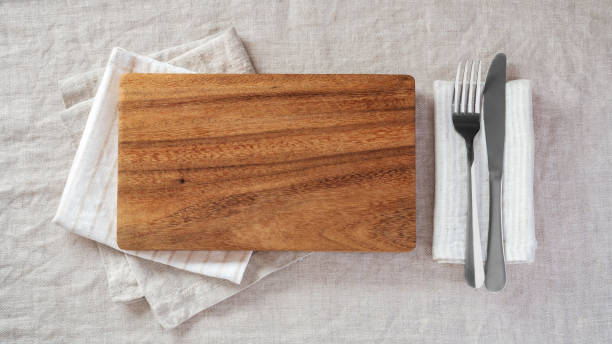 istock Wood plate with fork and knife on napkin on linen tablecloth 1582904016