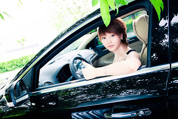 bella ragazza seduta nella sua nuova auto nera - car phone foto e immagini stock