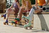Cropped shot of three teenage girlfriends in long socks and roller skates