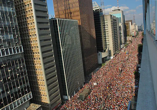 Gay Parade on streets of Sao Paulo, Brazil. Considered to be the world's largest including many gay people, tourists and people who support the Pride Parade. Paulista Avenue, important tourist destination and financial center.