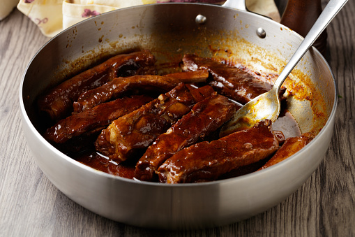 close view of honey glazed pork ribs in a pan