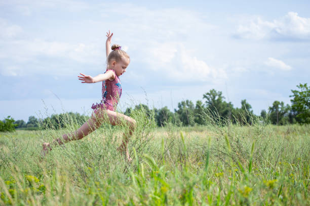 a gymnast in a beautiful swimsuit performs elements in nature