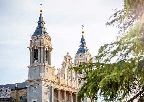 Close photo of bell towers of Almudena Cathedral on Plaza de la Armeria town square in Madrid