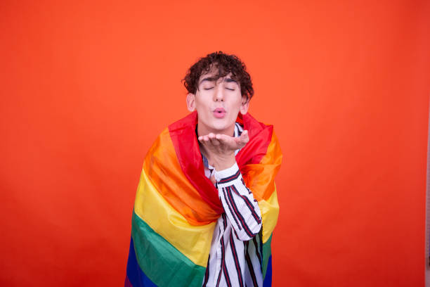 istock Young attractive guy posing in the studio on an orange background. 1582991107