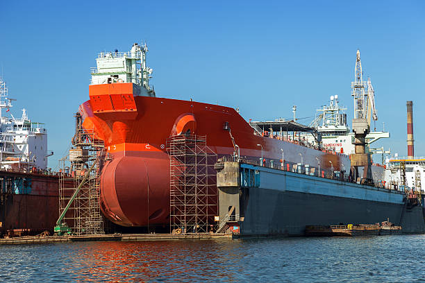 Large red tanker in the dry dock A large tanker repairs in dry dock. Shipyard Gdansk, Poland. dry dock stock pictures, royalty-free photos & images