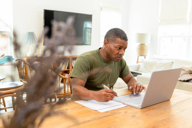 istock Mature male soldier sits at the table to work on his continuing education classes 1583010252