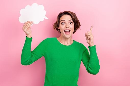 Photo of young surprised funny woman hold bubble cloud genius idea eureka point finger up decision isolated on pink color background.