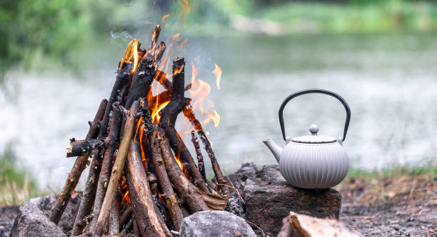 istock Small kettle is heated on a bonfire, outdoor recreation concept. 1583024503