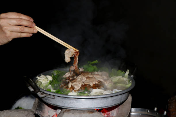 istock Women's hands are using chopsticks to grilled pork , Thai Barbecue Buffet with smoke 1583027228