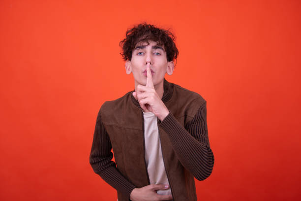 istock Work in advertising. Funny guy posing on an orange background. 1583039233