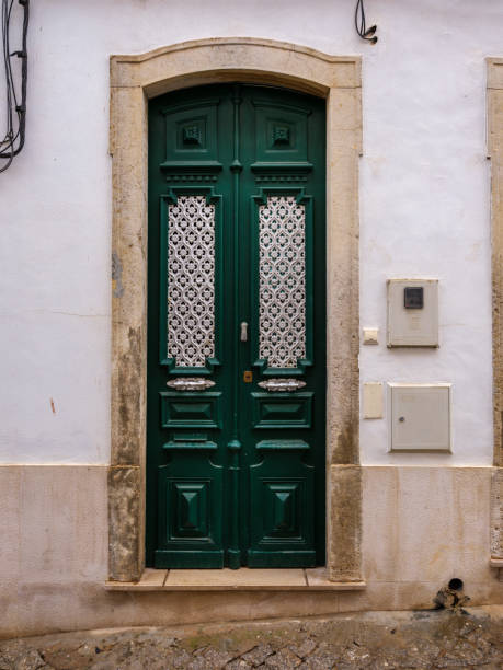 Antique metallic door on a white wall.