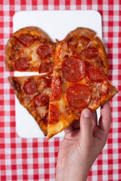 istock heart shaped pizza on white and red checkered tablecloth for valentine's day 1583041444